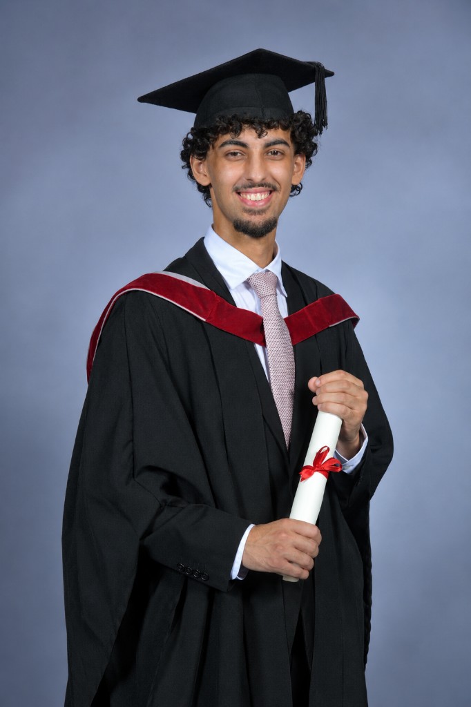 Hamza Chennou in graduation attire holding a diploma
